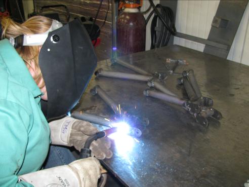 Welding the front A-arm assembly in the shop
